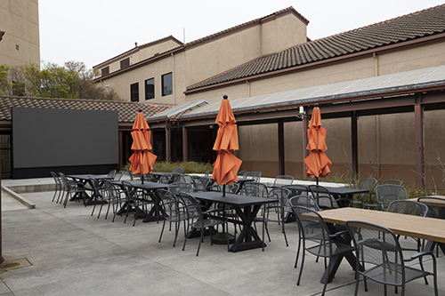 courtyard outside the courtyard cafe - tables with umbrellas and a large screen